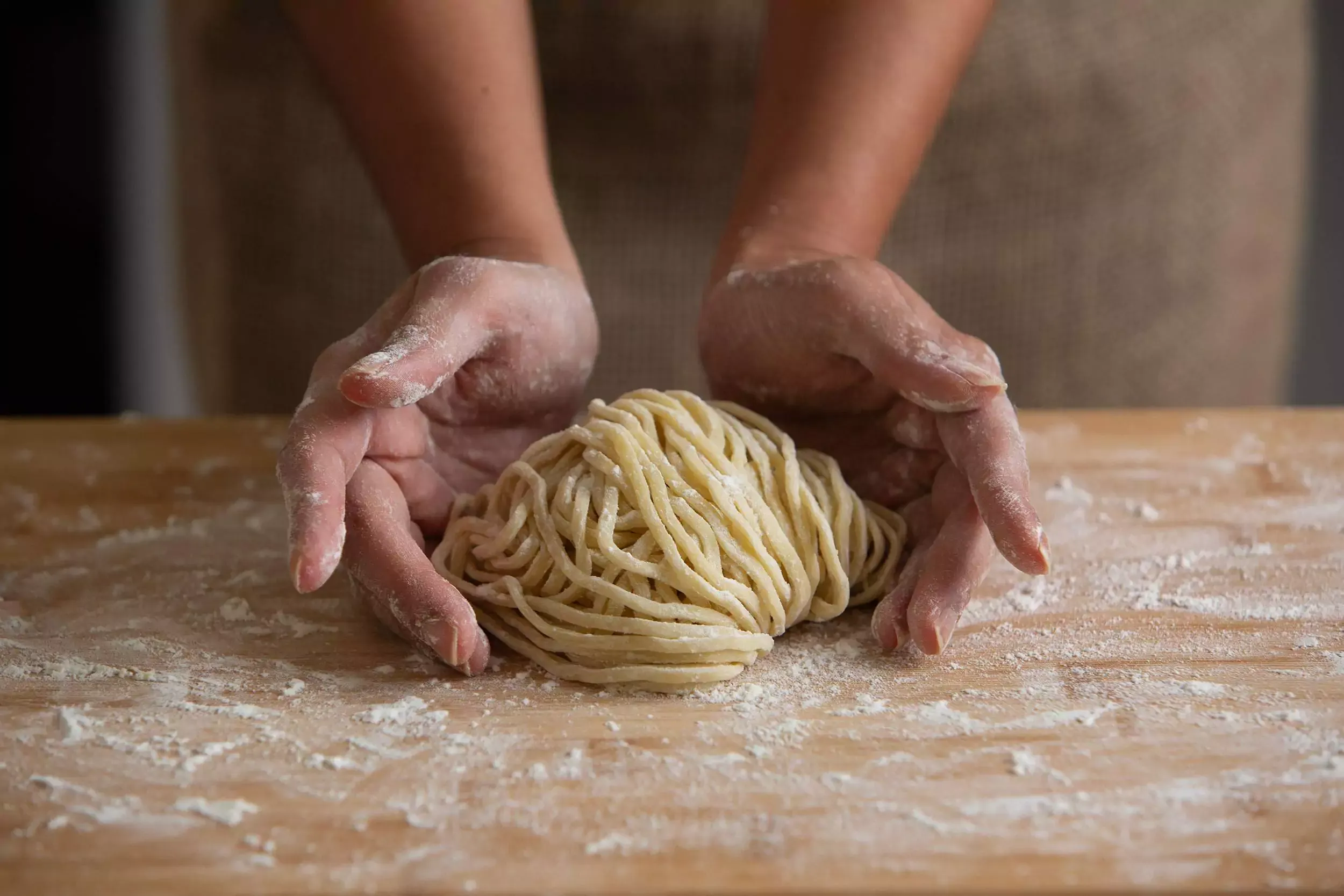An image of hands shaping noodles